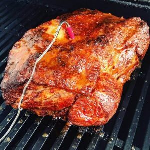 Pulled Pork Pork butt cooking on a BBQ