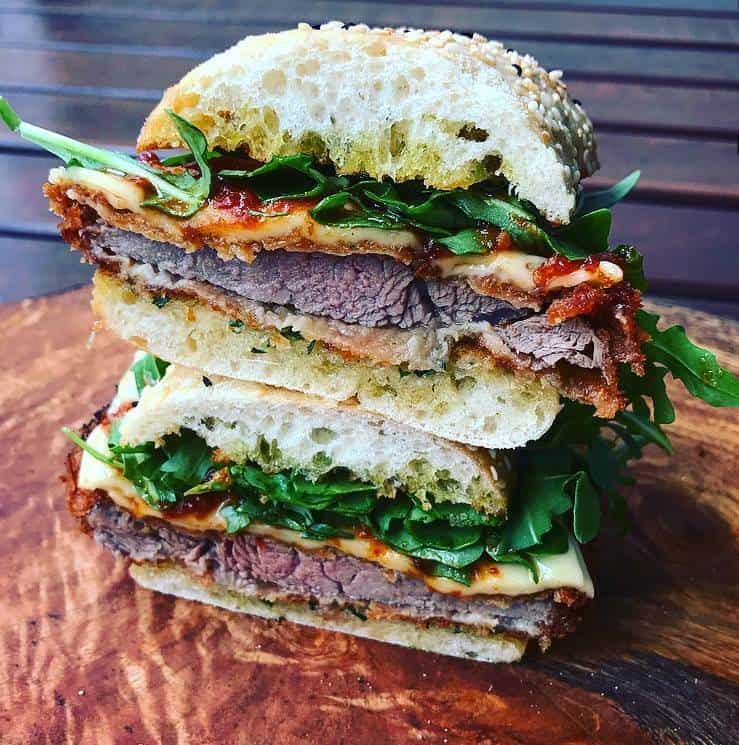 Veal Parm Sandwich Veal parm sandwich cut in half on wooden board