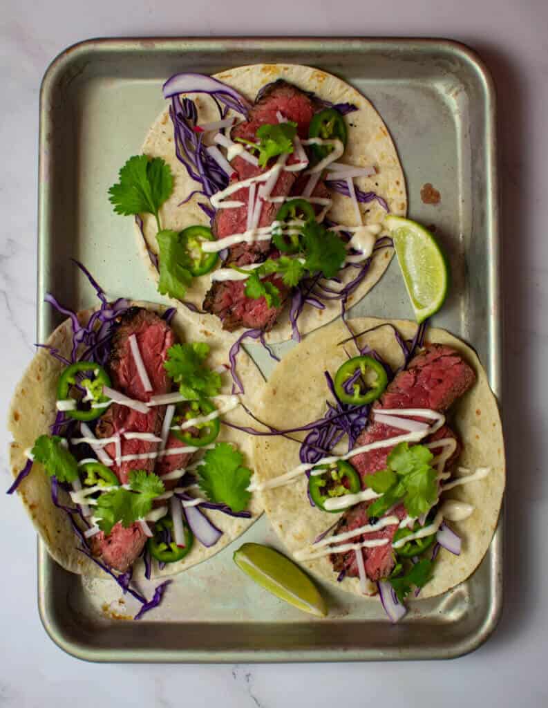 3 steak tacos - carne asada style on a tray