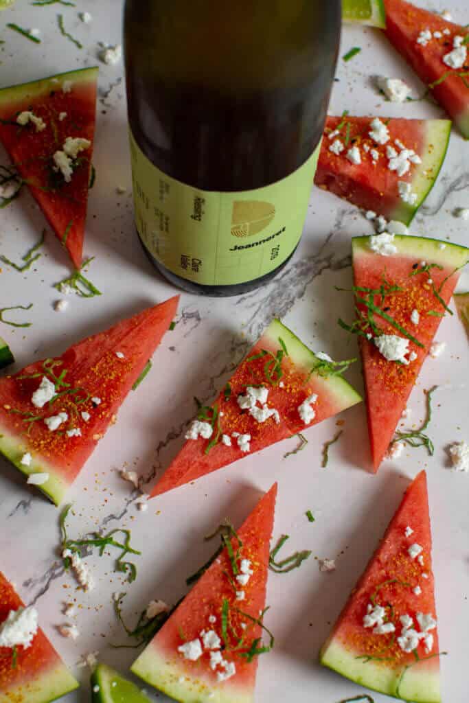 watermelon topped with togaroshi, mint & feta. Bottle of Jeanneret riesling next to them