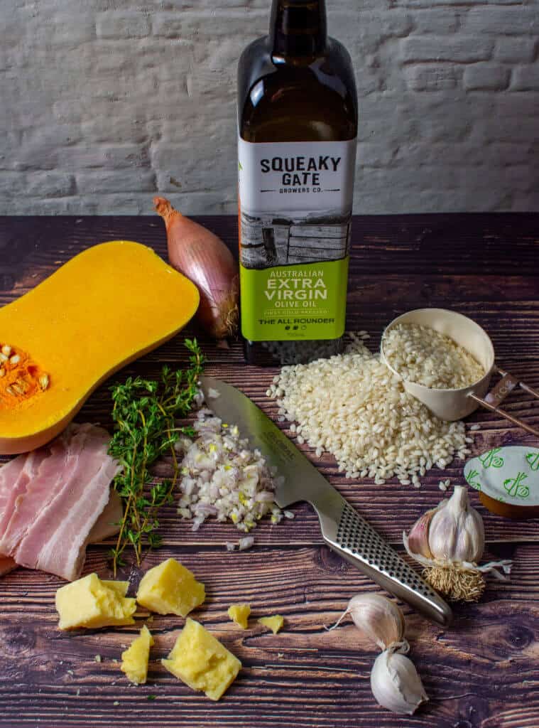 squeaky gate olive oil, pumpkin, bacon, risotto rice & a global chef knife on a table
