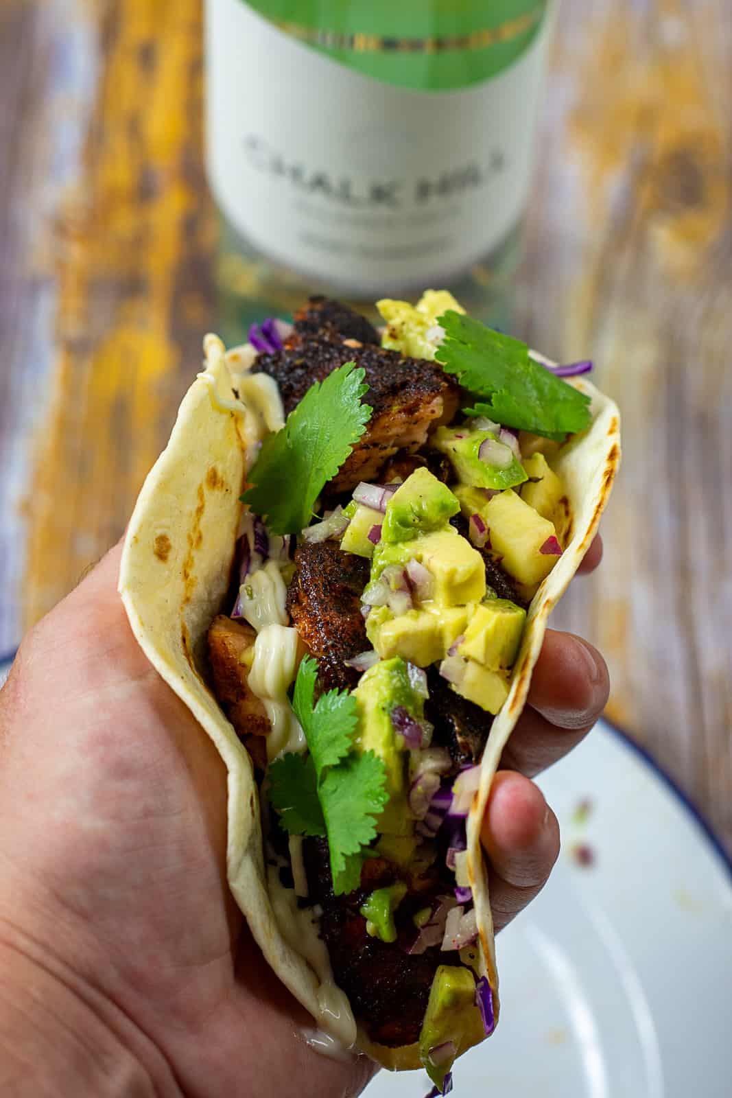 someone holding a blackened salmon taco