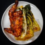 1/2 chicken, asian veg on a white plate