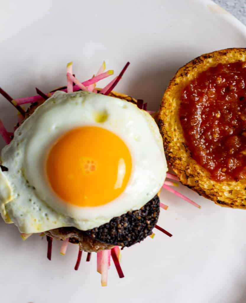 Birds eye view of pork & black burger with a sunny side up egg