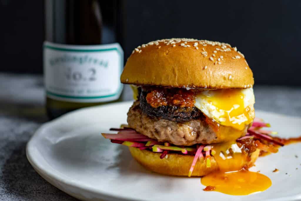Pork & black pudding burger with runny egg yolk. Bottle of rieslingfreak riesling in background