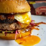 Close up of pork & black pudding burger with runny egg yolk. Clonakilty black pudding packet in background