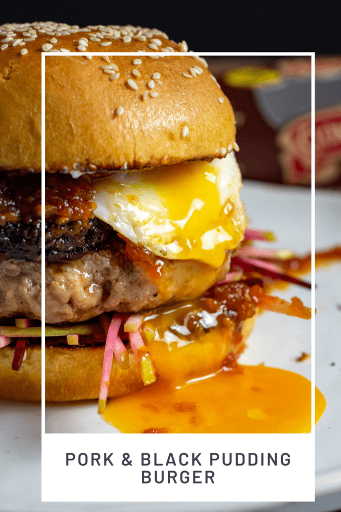 Close up of pork & black pudding burger with runny egg yolk. Clonakilty black pudding packet in background