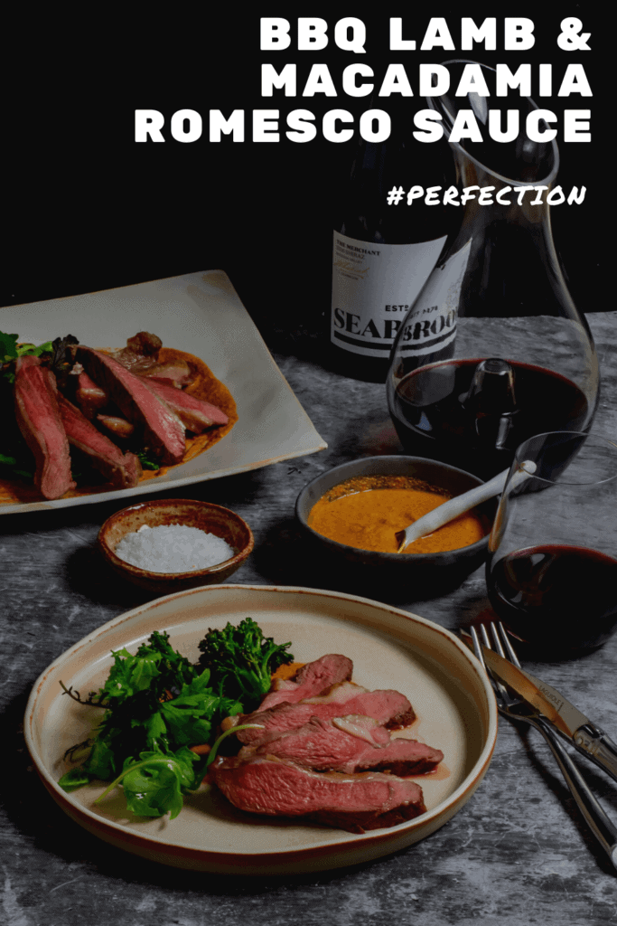 Seabrook wine shiraz, wine decanter, cooked lamb, macadamia romesco sauce & charred broccolini on a table