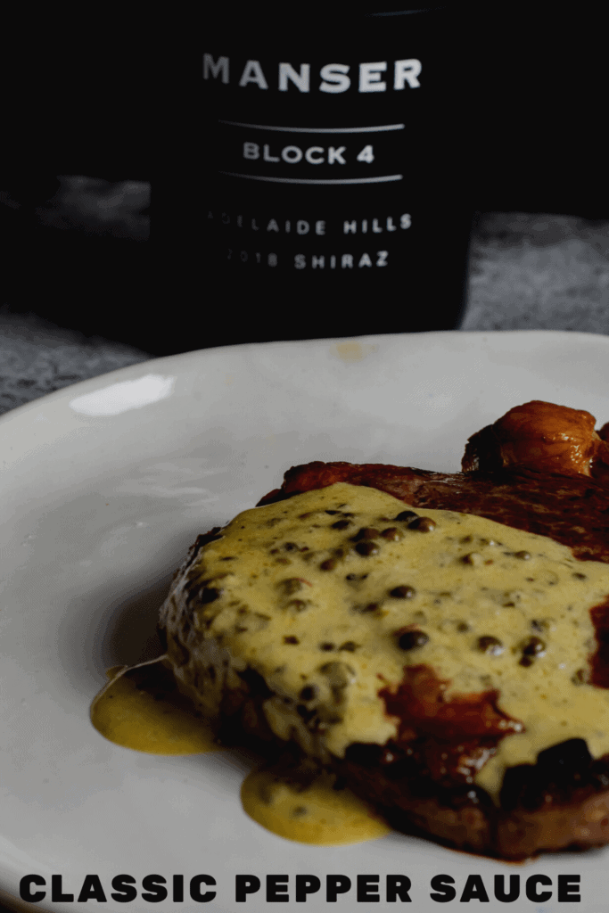 steak, peppercorn sauce on a plate with manser red