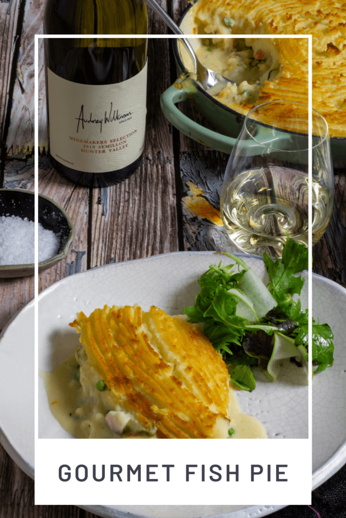 fish pie, glass of wine, wine bottle and salad