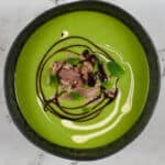 A bowl of pea & ham soup on kitchen countertop