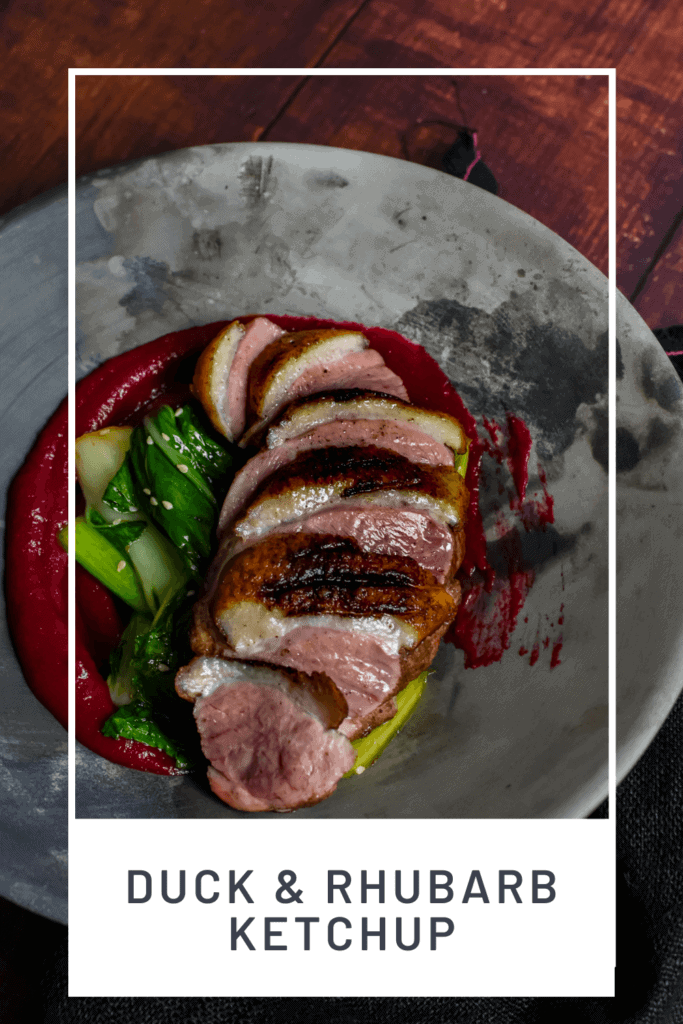 Duck breast, rhubarb ketchup & asian greens in a made of australia bowl on a table