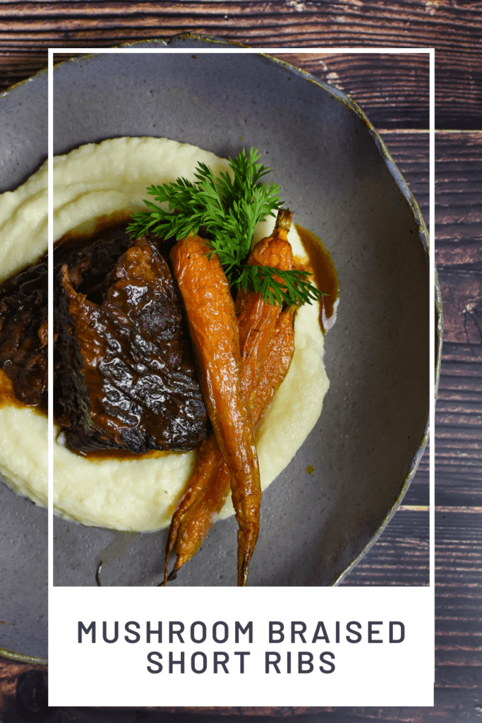 mushroom braised short ribs, cauliflower puree & carrots in a bowl on wooden table