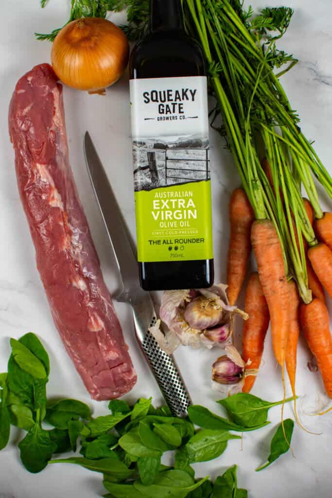 pork tenderloin, carrots, garlic, spinach & squeaky gate olive oil on kitchen counter top