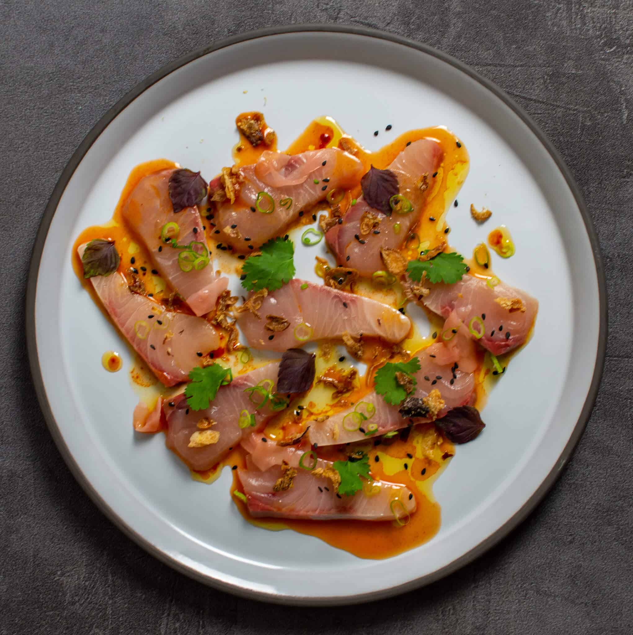 beautiful kingfish crudo on a CB2 plate