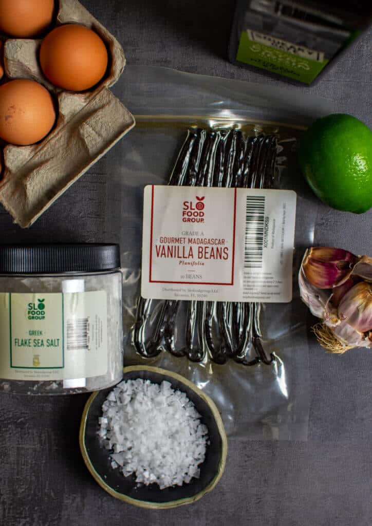 slofoodgrp vanilla, eggs, salt, lime & garlic on counter top