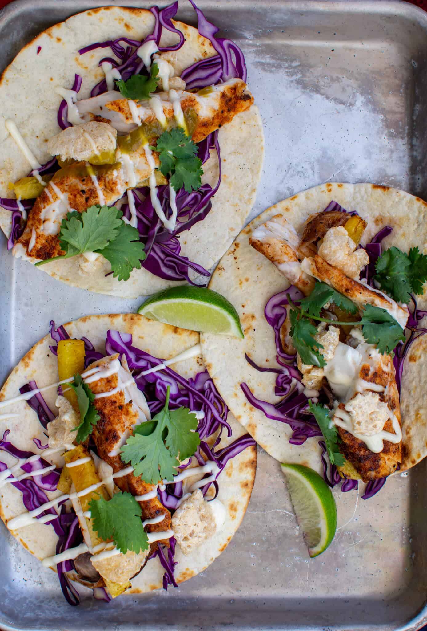 3 grilled fish tacos on a tray