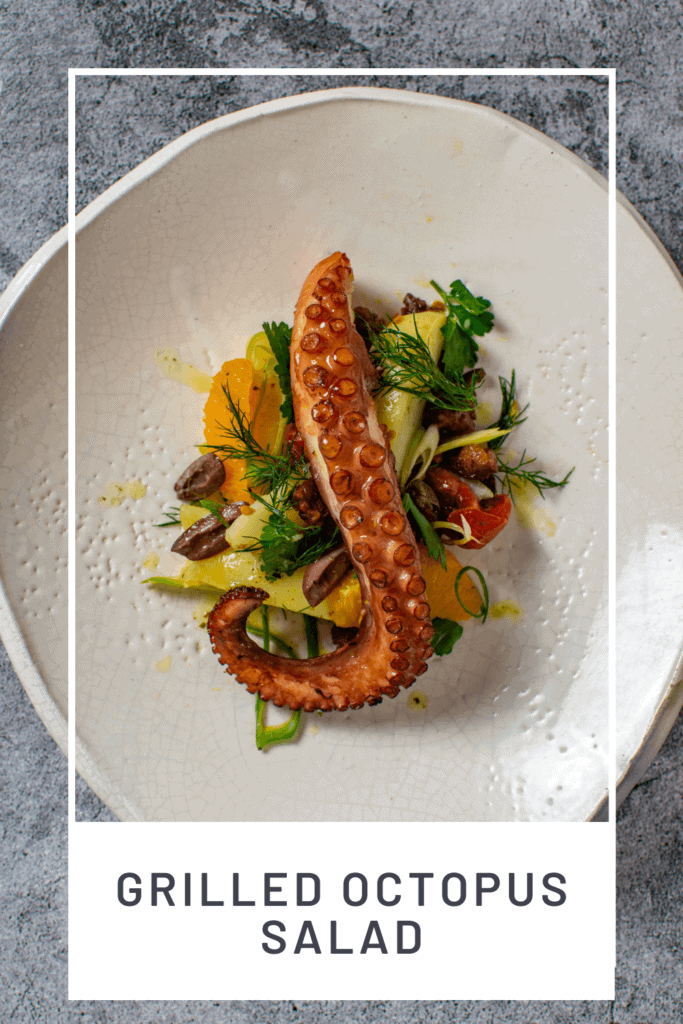 Grilled octopus salad on a white plate