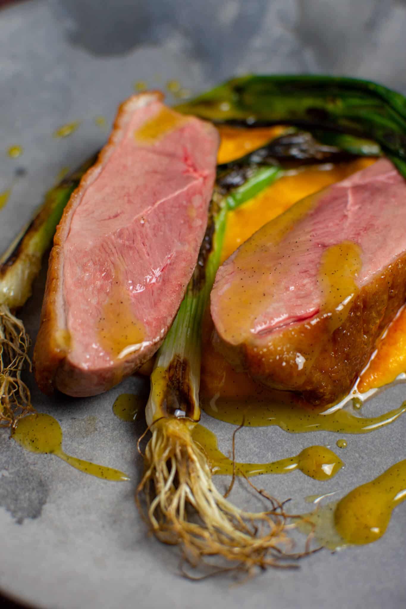 perfectly cooked duck breast, carrot puree & orange sauce on a made of australia plate