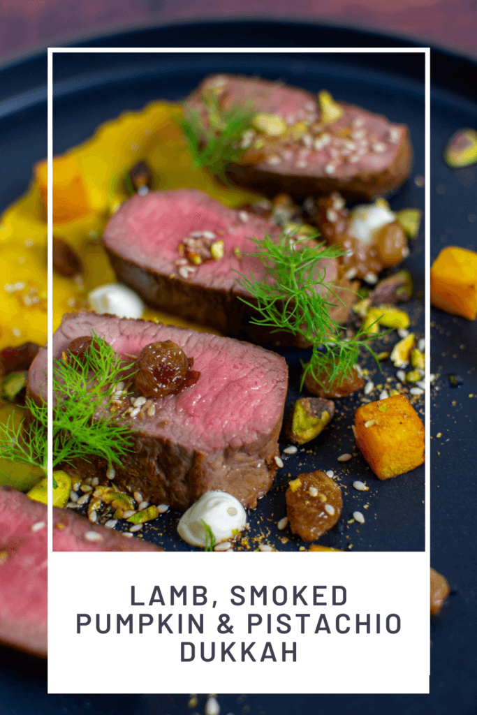 lamb, smoked squash puree, & pistachio dukkah on a black plate