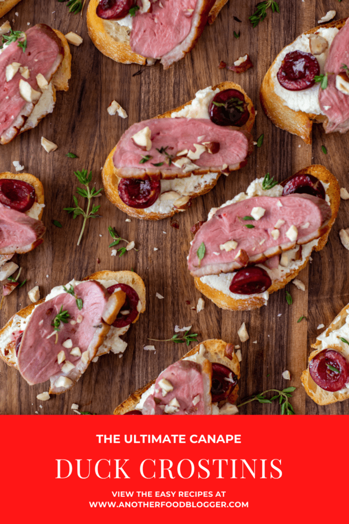 duck crostinis with cherries & goat cheese on wooden chopping board