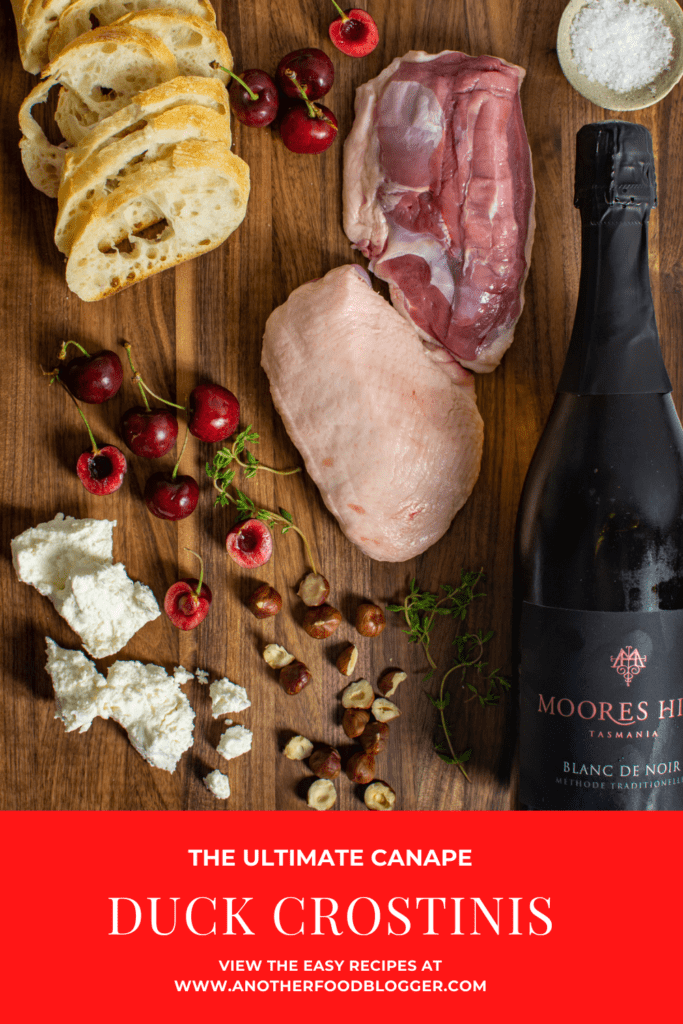 duck breast, goat cheese, baguette & bottle of moores hill sparkling wine on a chopping board