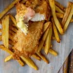battered fish & chips & pickled ginger on a wooden table