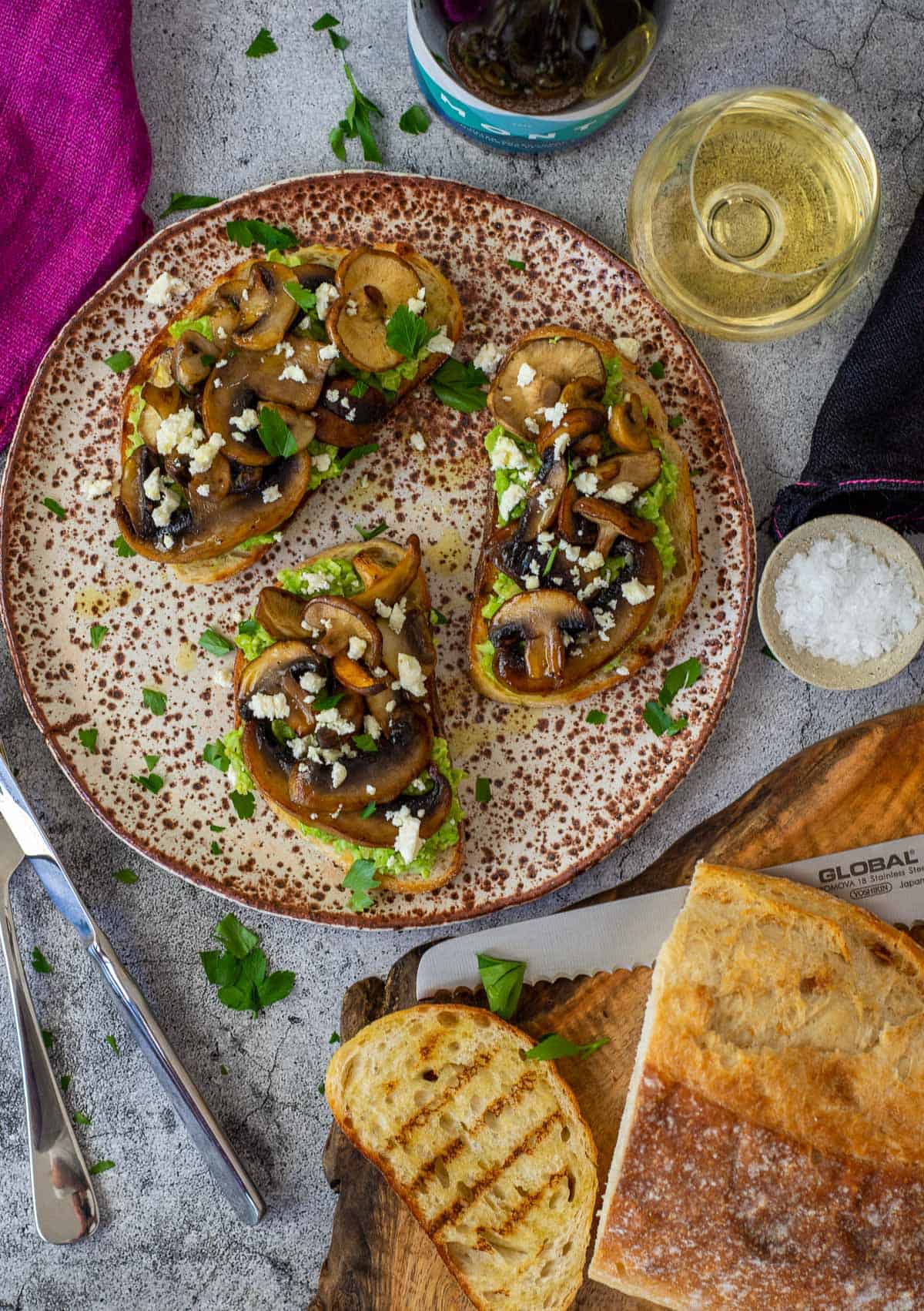 mushroom avocado toast on a plate with bread on chopping board and mont wines chardonnay