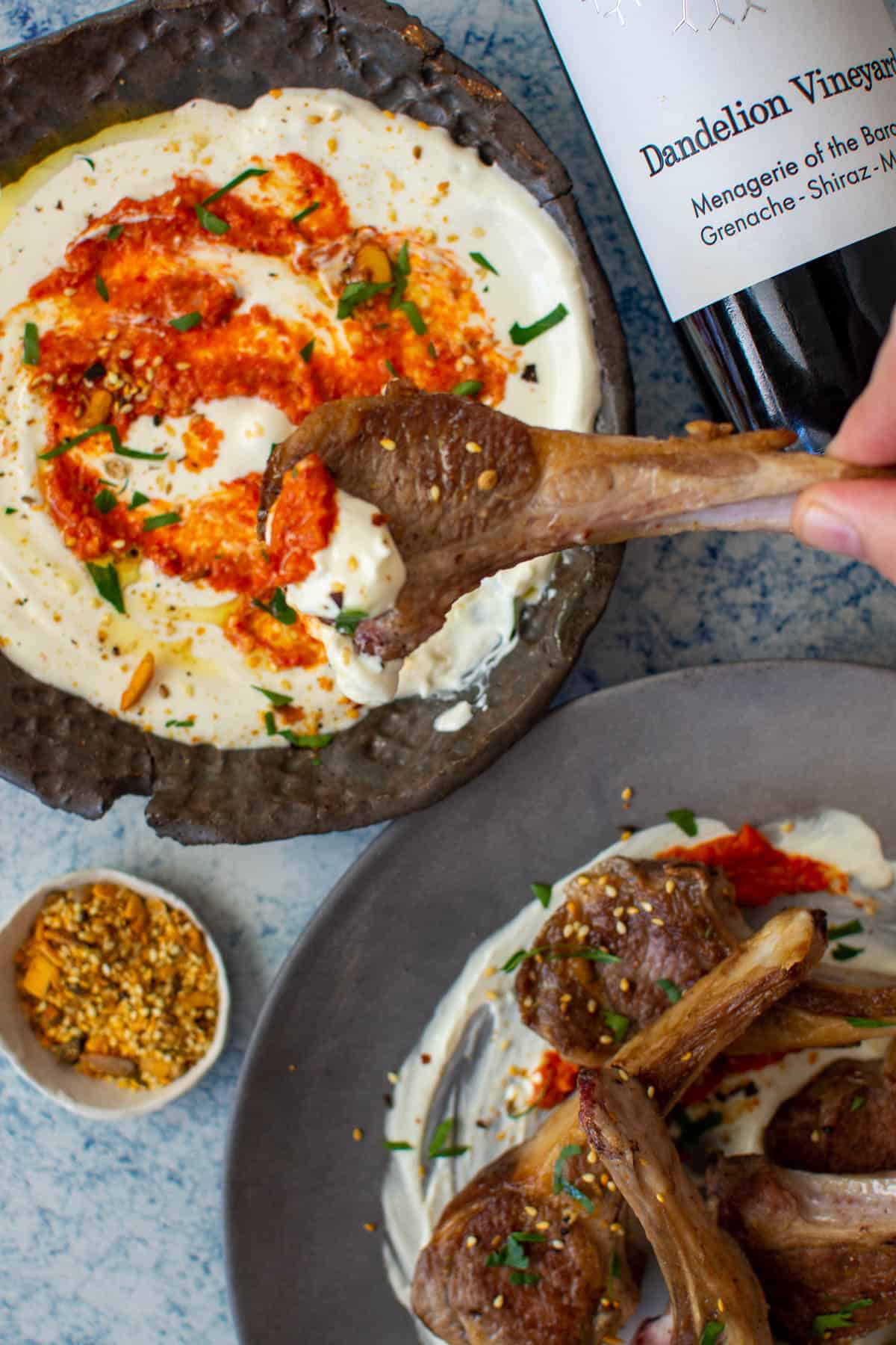 grilled lamb chops with labneh and harissa on a plate