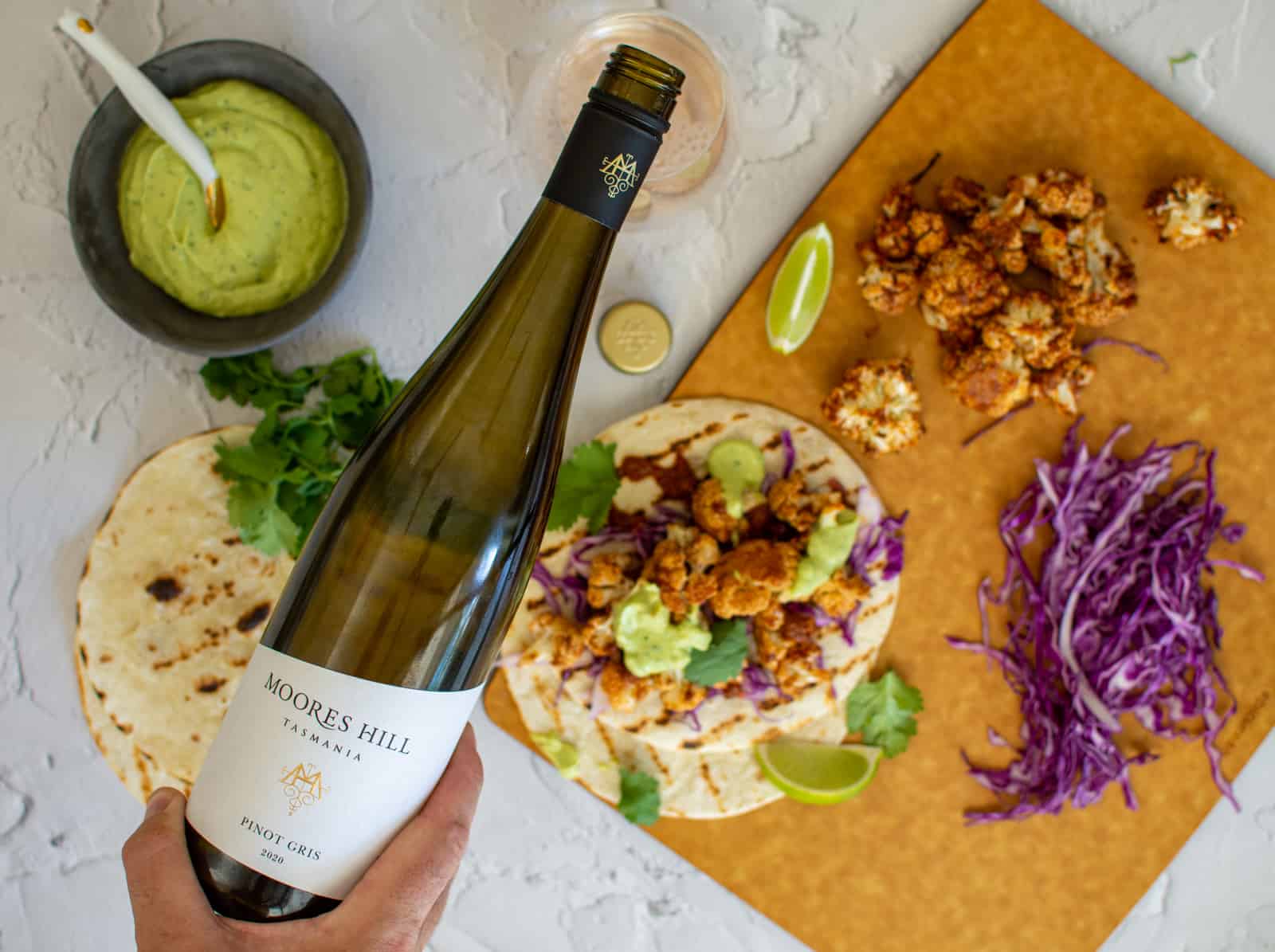 moores hill pinot gris being poured from above - cauliflower tacos beneath the bottle