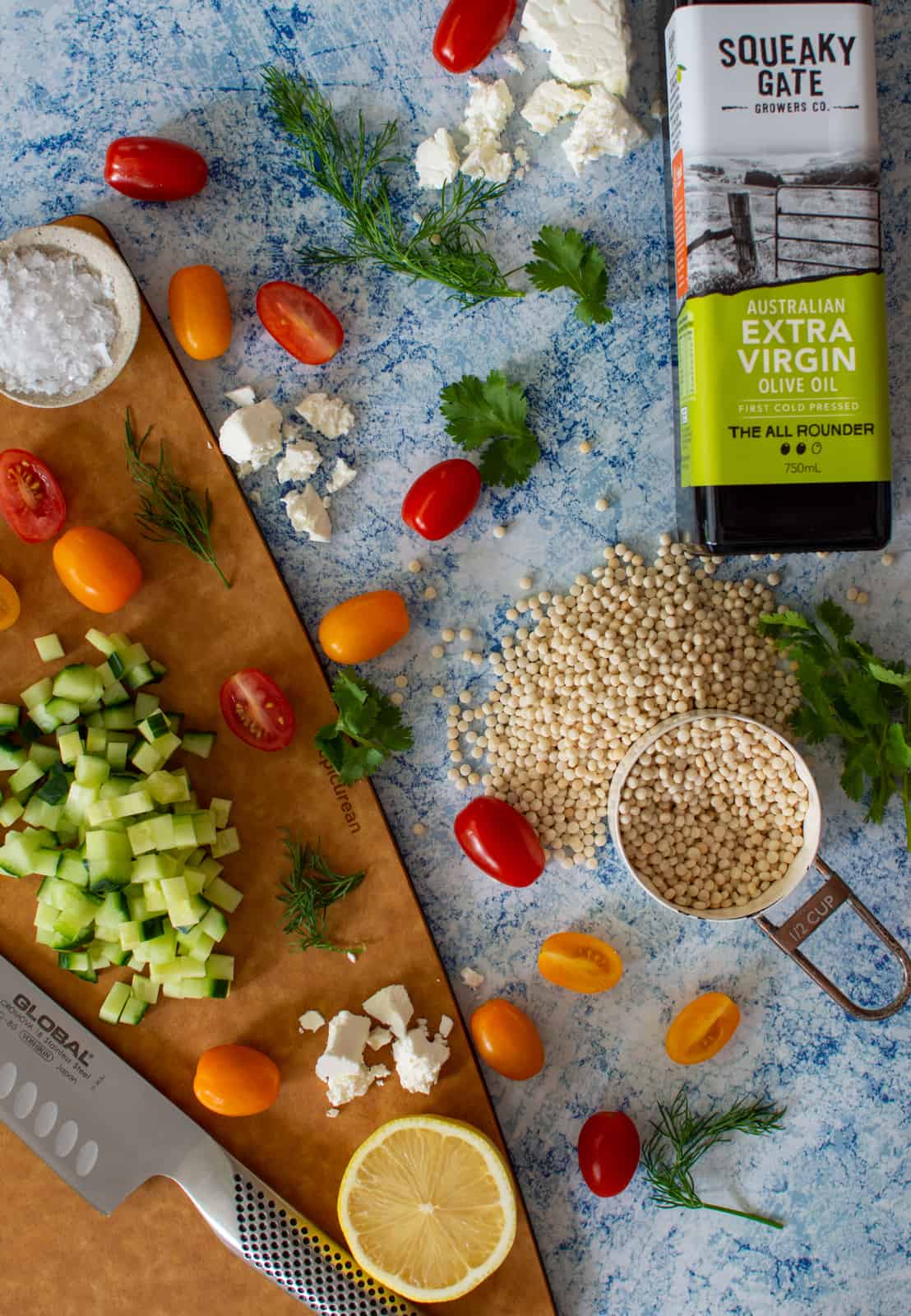 squeak gate olive oil, pearl cous cous and vegetables on a chopping board