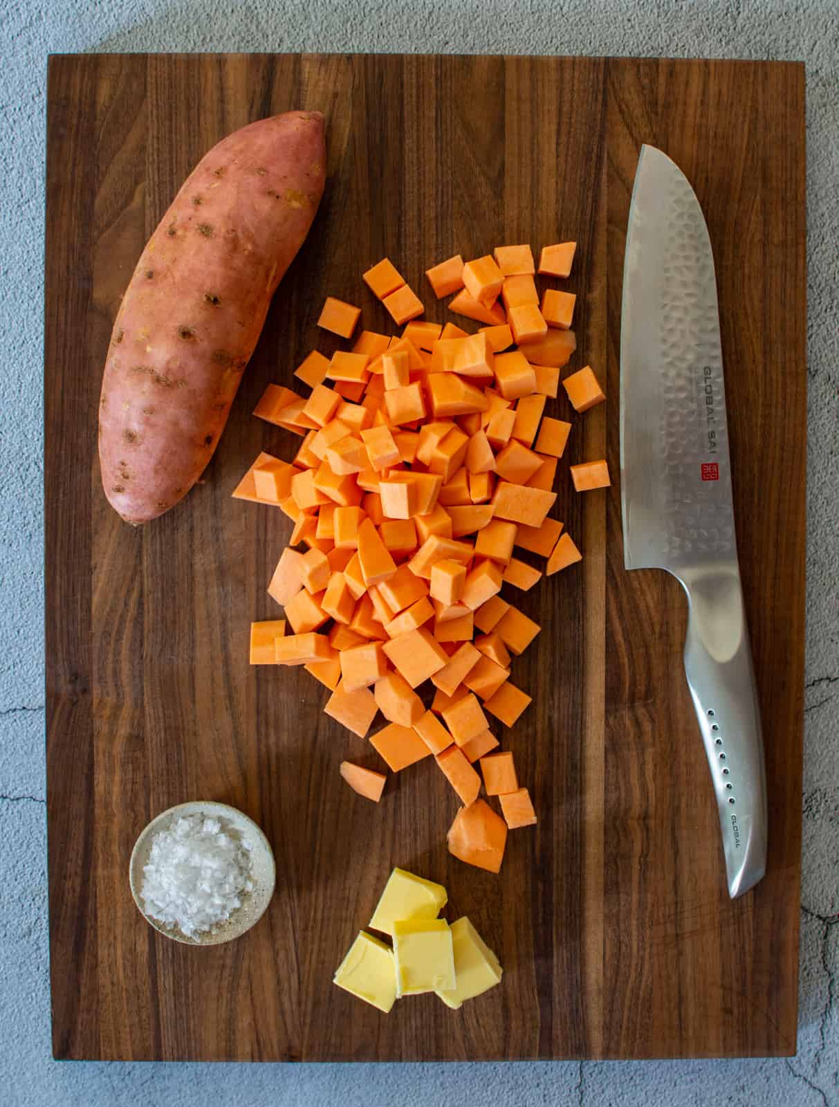 sweet potatoes & globa chef knife on chopping board