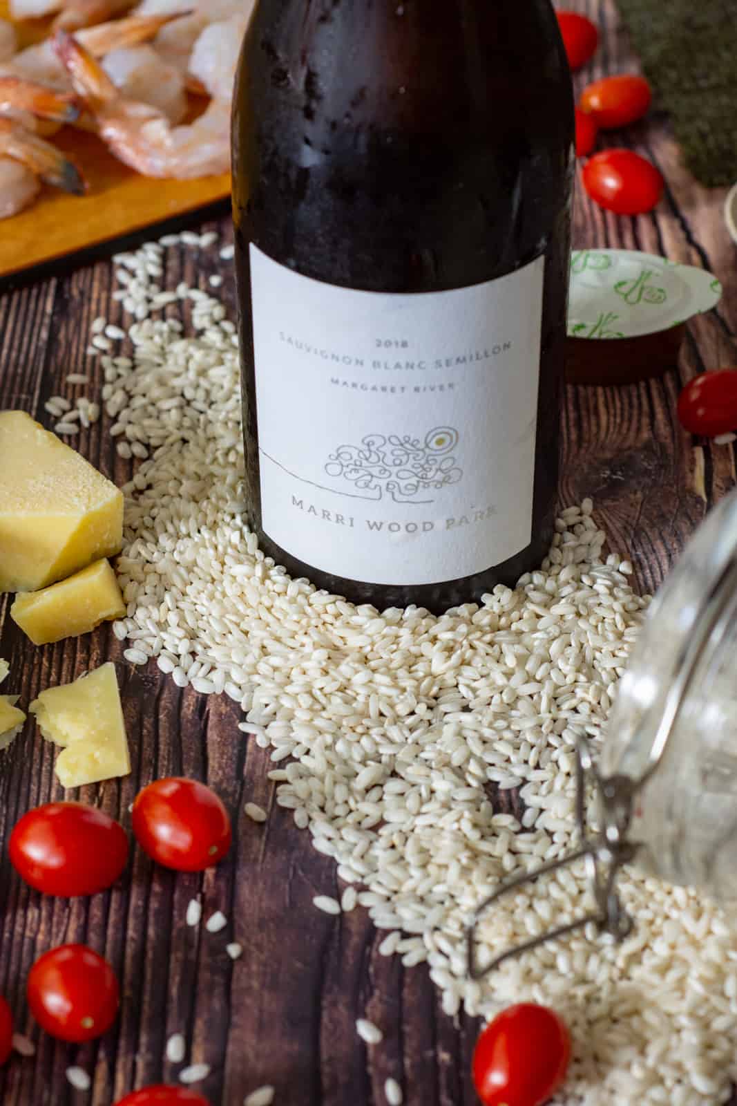 marri wood park sauvignon/semillon wine, arborio rice, tomatoes and parmesan on a wooden table