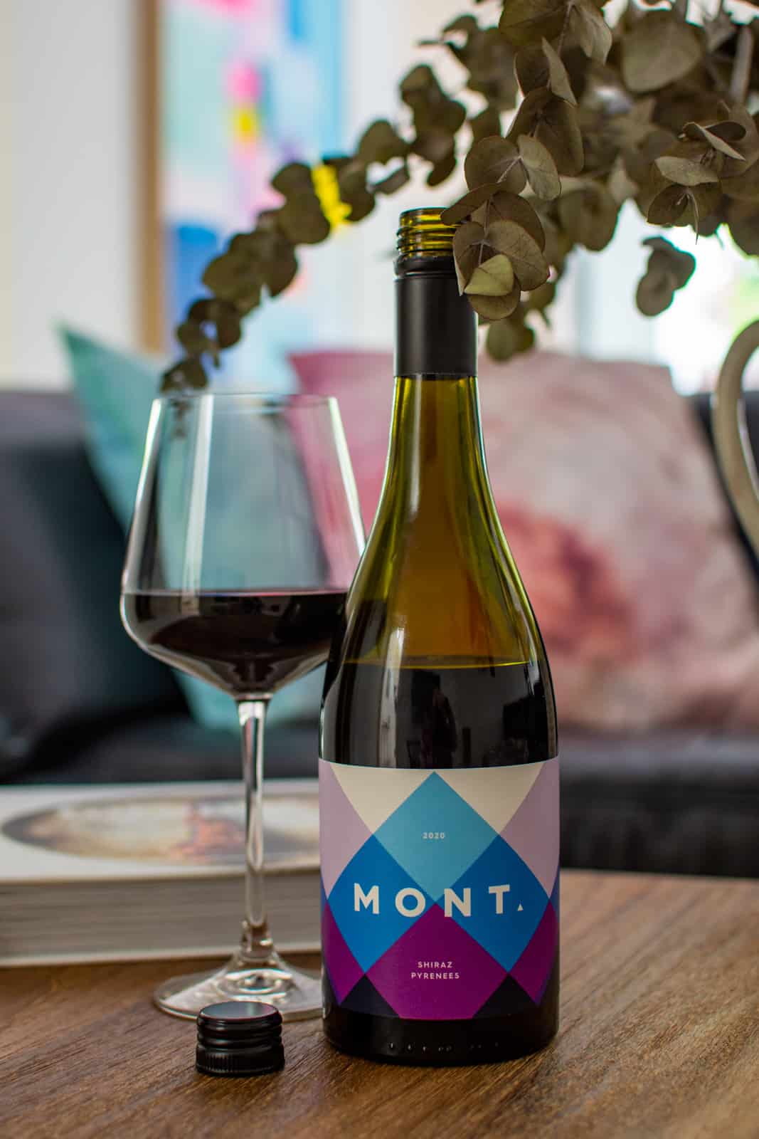 mont wines shiraz bottle and wine glass next to dried flowers