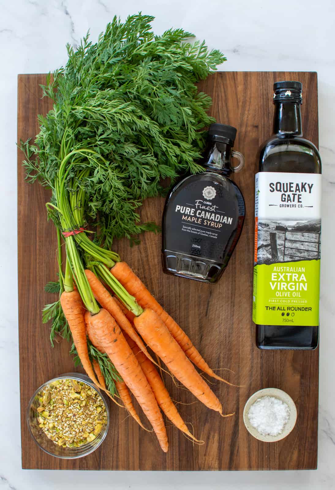 carrots, olive oil and maple syrup on a board