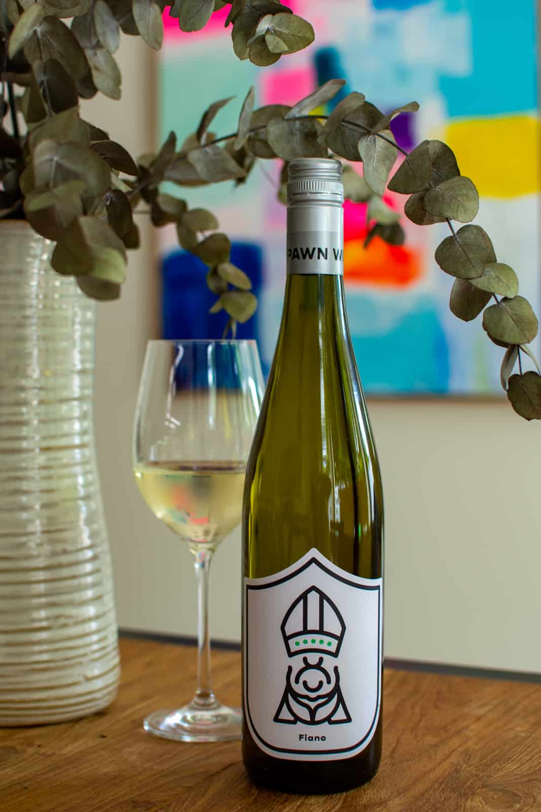 The Pawn Wine Co Fiano wine on a table with glass of wine next to it