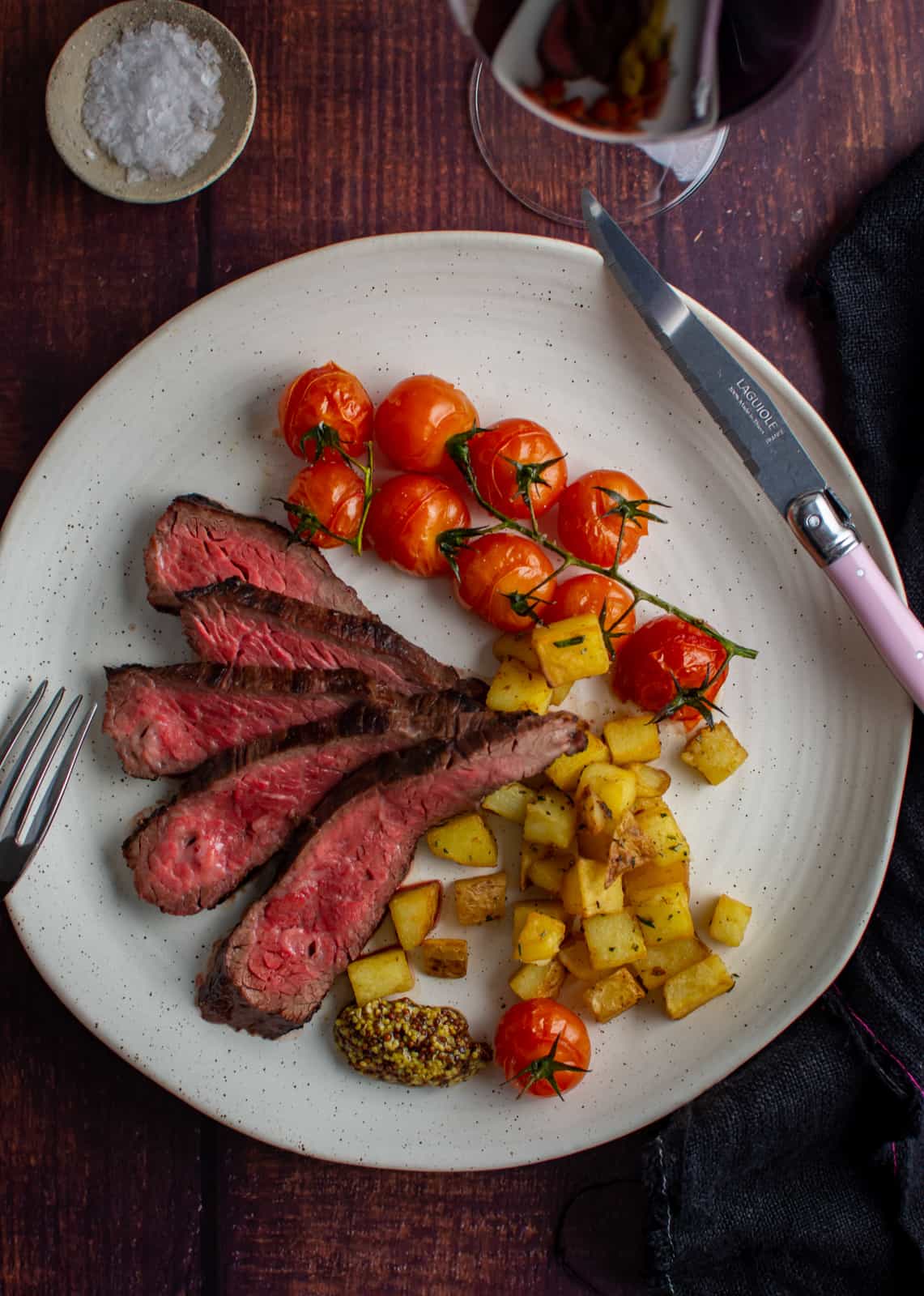 bavette steak, parmentier potatoes & tomatoes on a white plate
