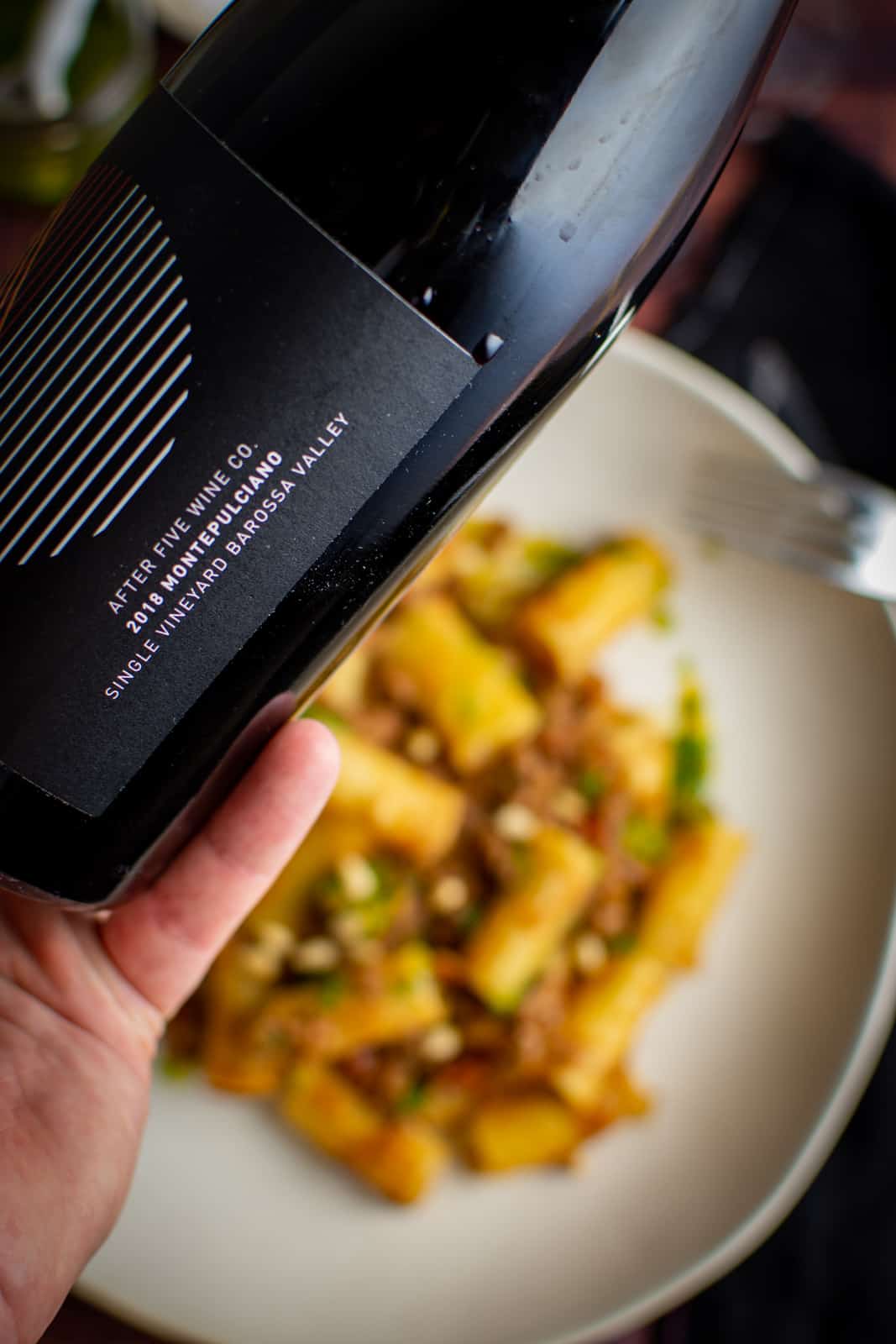 close up of After five wine co montepulciano with lamb mince ragu below