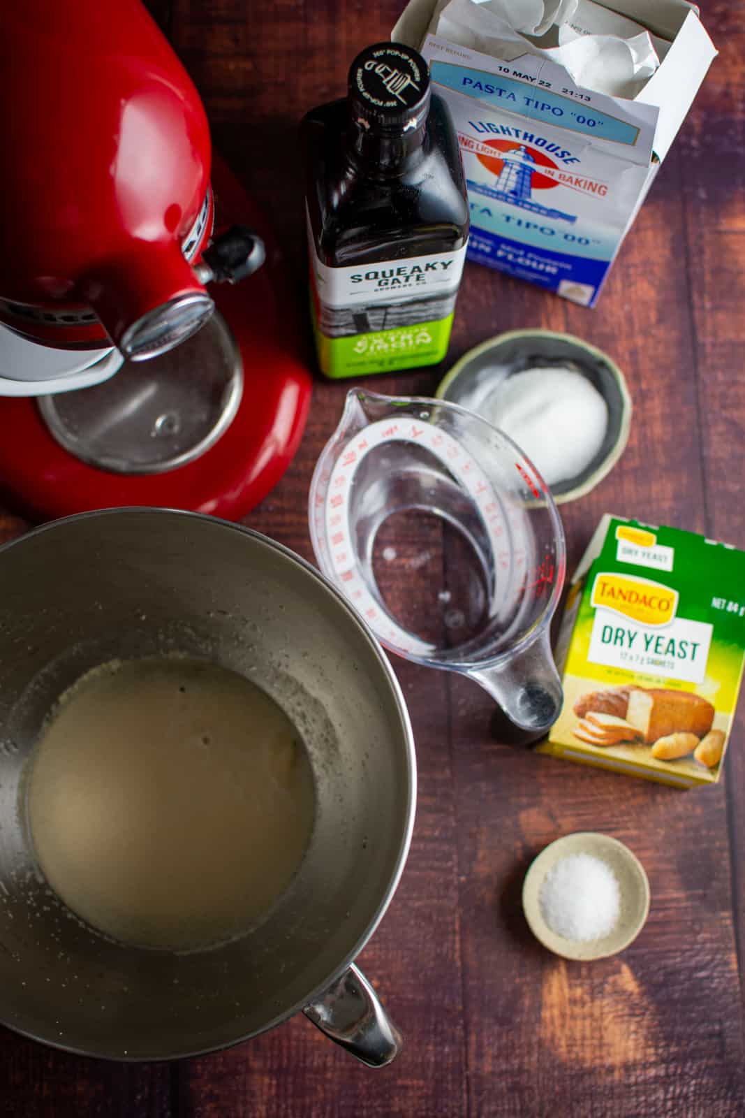 Ingredients for homemade pita, kitchen aid and warm water/yeast in a bowl