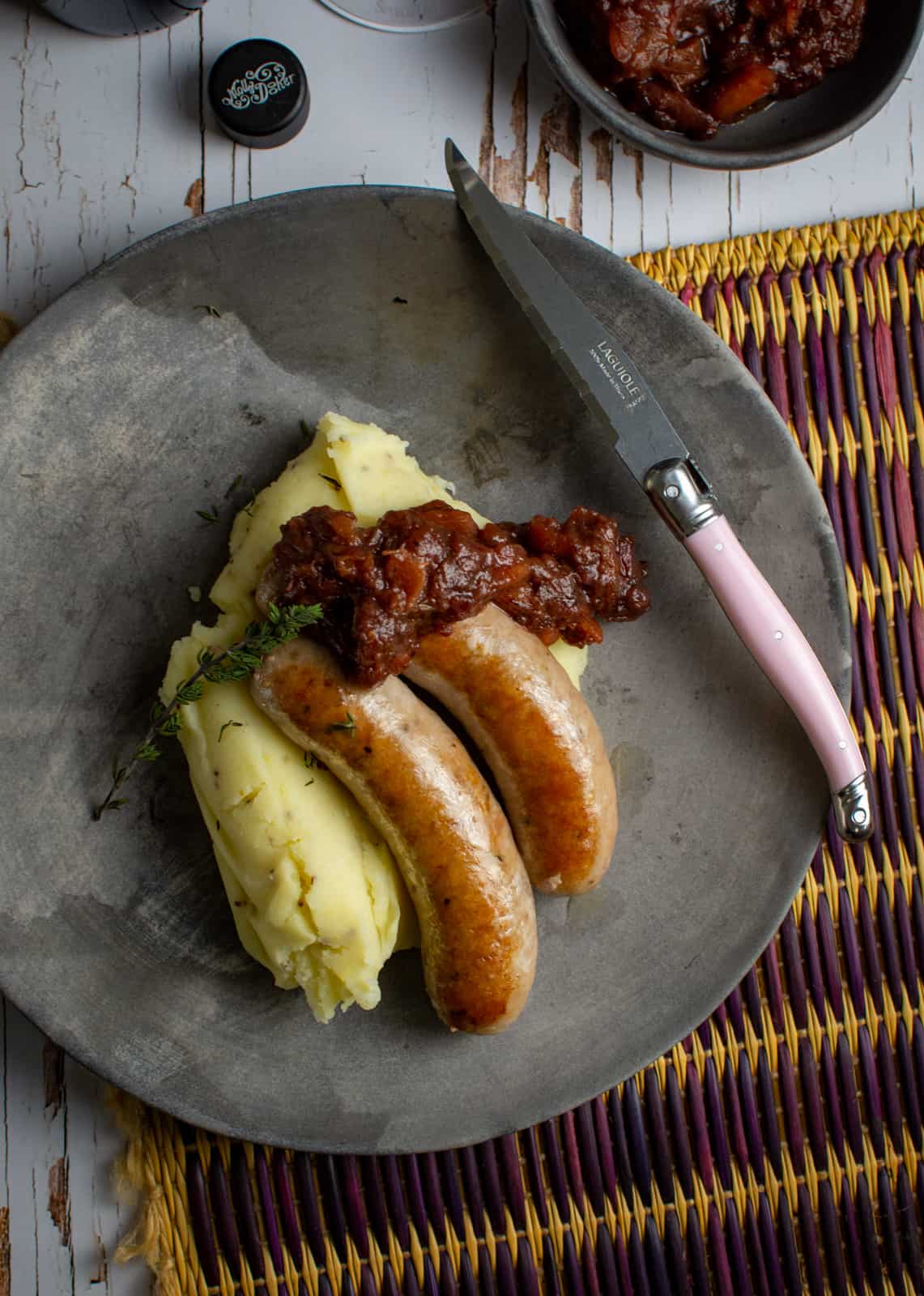 bangers and mash on a plate on a wooden table