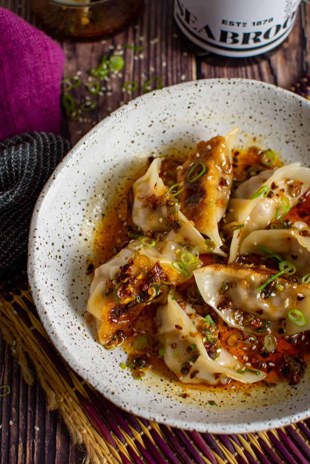 A bowl of pork cabbage dumplings lathered with szechuan chilli sauce