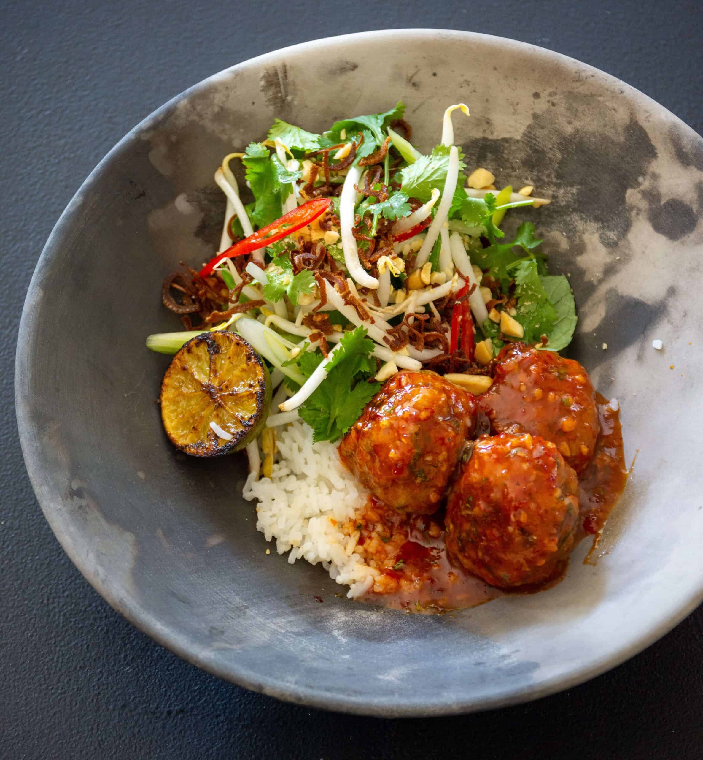 Asian pork meatballs Asian pork meatballs in a bowl with rice and beansprout salad