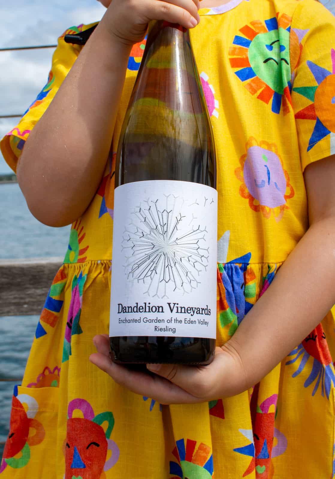 A girl holding a bottle of dandelion riesling