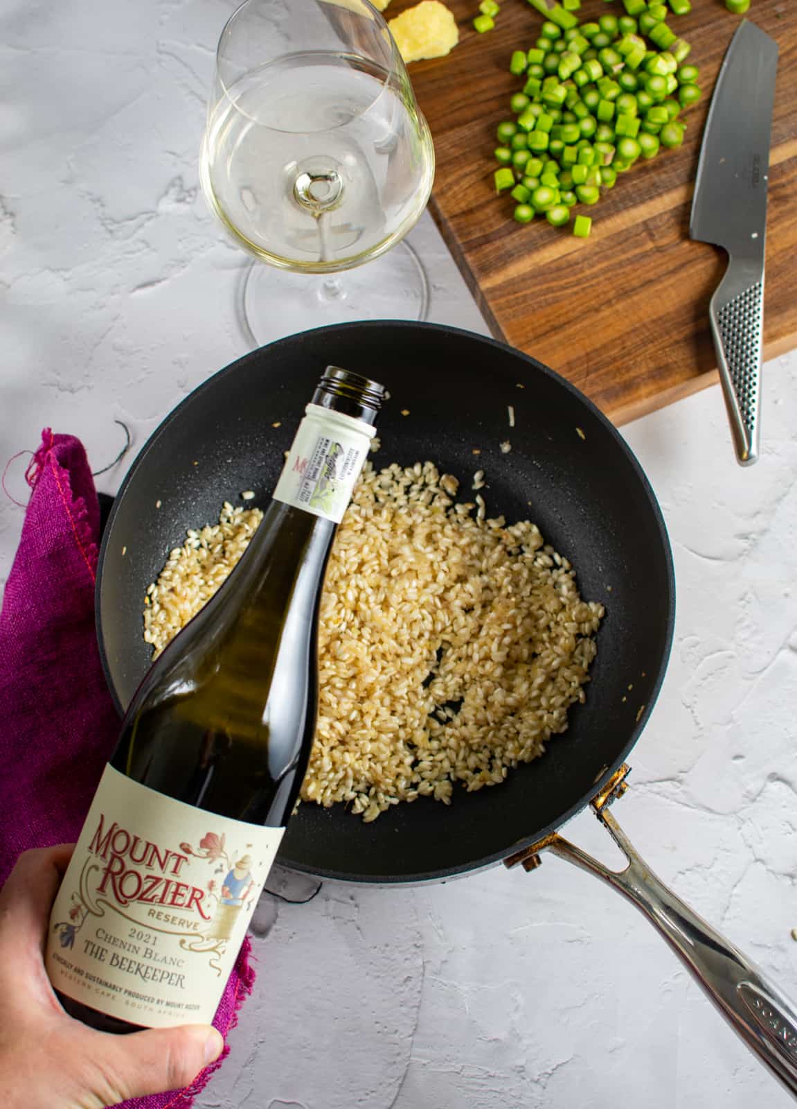 wine being poured into frying pan for risotto