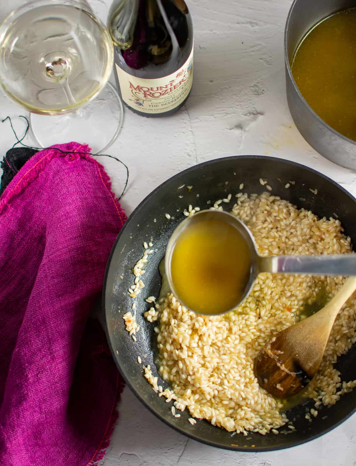 stock being ladeled into crab risotto