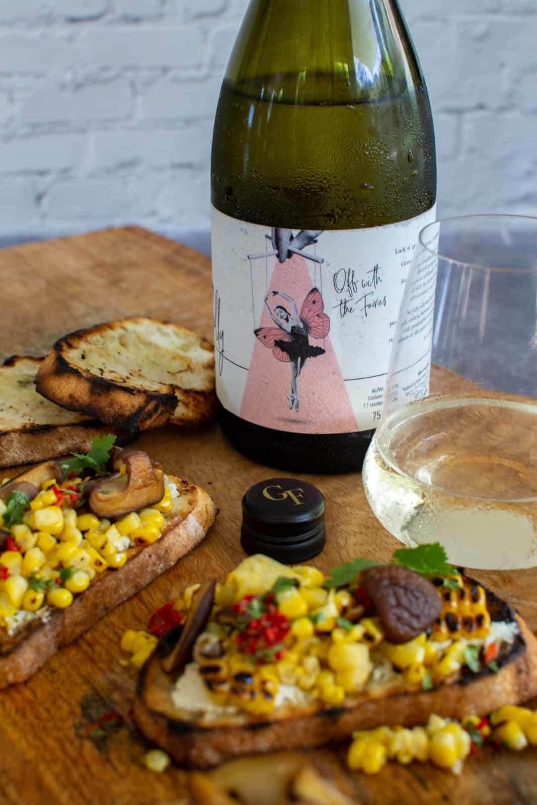 Georges Folly rousanne wine on wooden board with veggie toast next to it