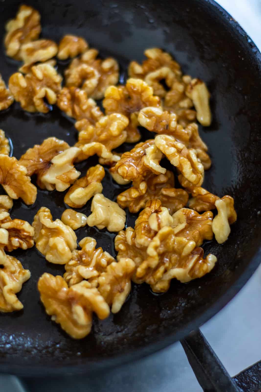 walnuts being candied in frying pan