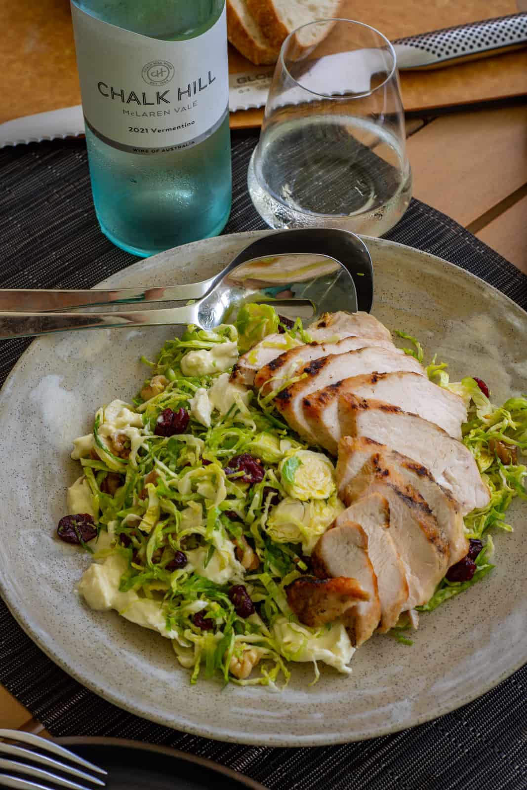 brussels sprout salad in a bowl on table, chalk hill vermentino beside it