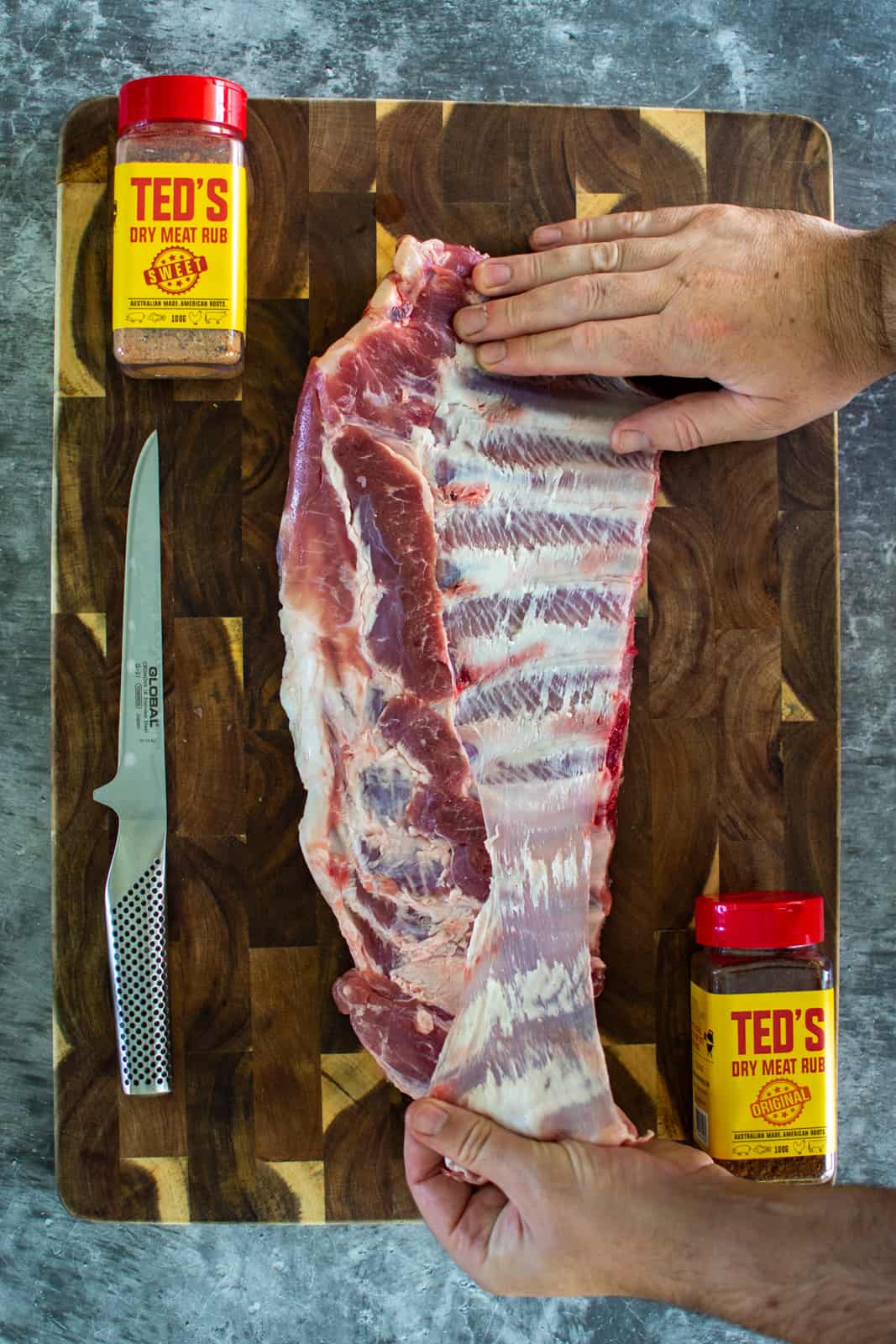 Someone pulling the membrane from pork spare ribs