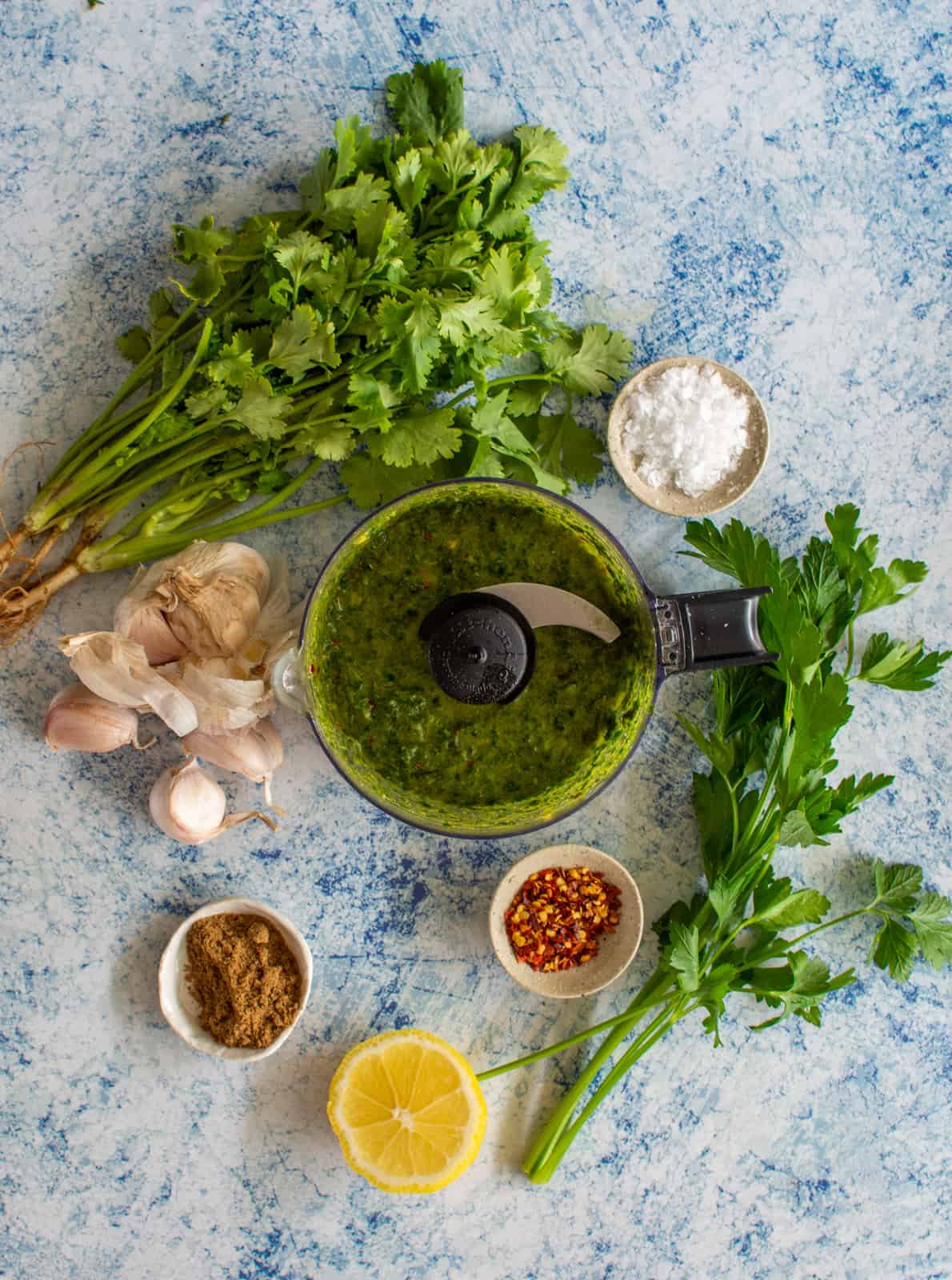 homemade chermoula ingredients on counter top with chermoula in a blender